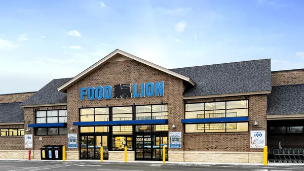A brick building with a "Food Lion" sign in blue letters beneath a pointed roof.