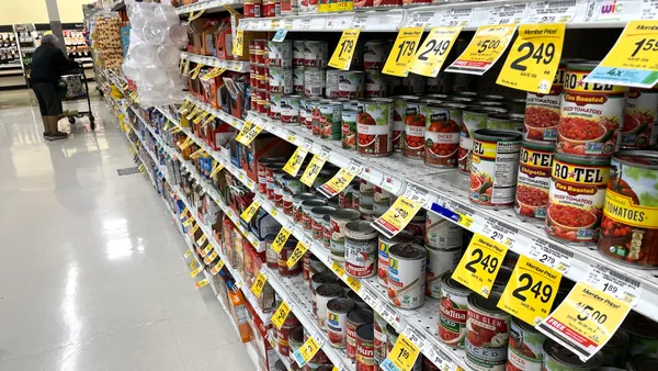 A grocery store aisle with multiple types of canned goods on sale