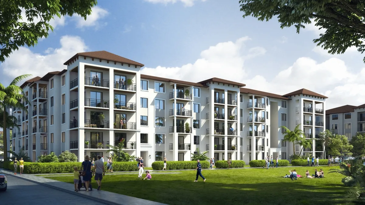 A white, mid-rise apartment building with many balconies.