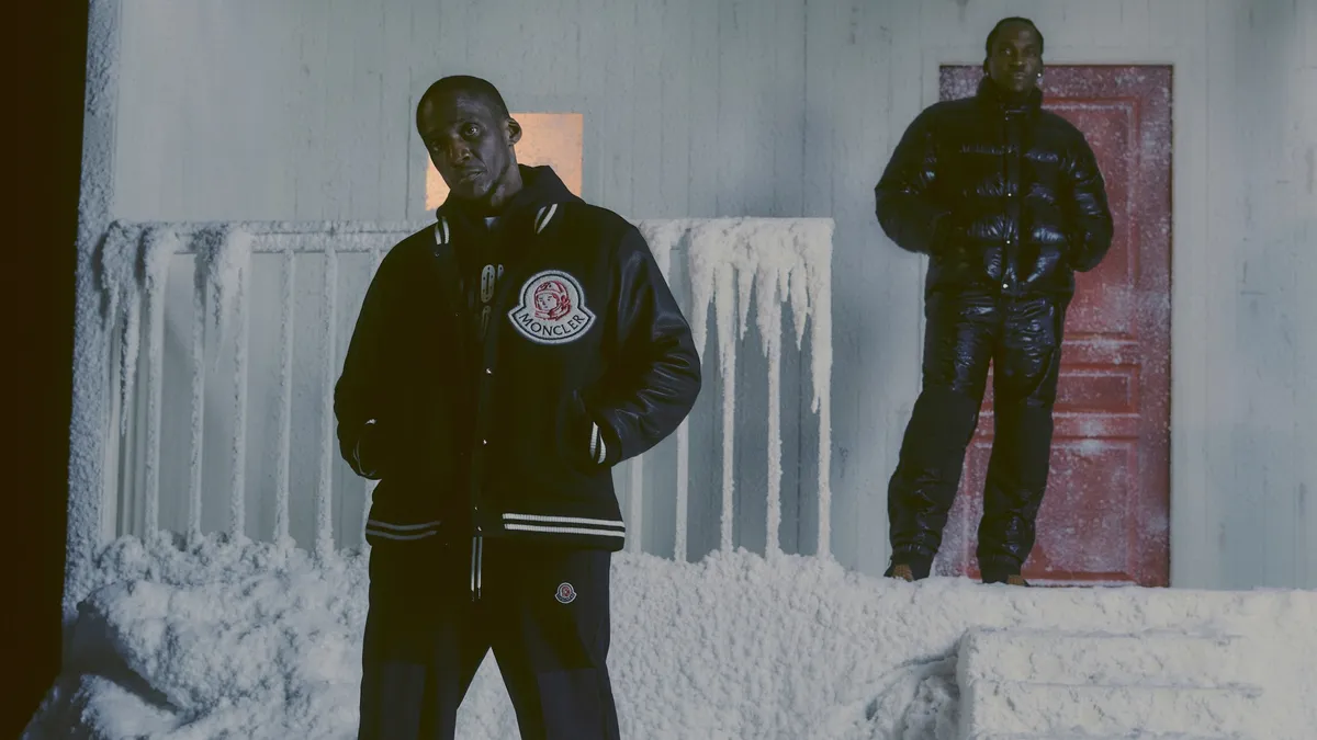 Two people from the hip hop duo Clipse wear Moncler x Billionaire Boys Club outfits and stand on frozen steps in an ad campaign for the brands.