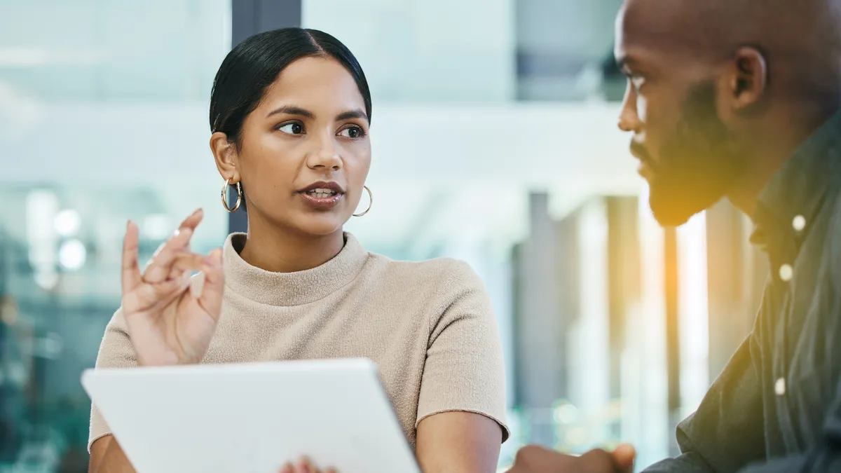 A woman explains a concept to a colleague