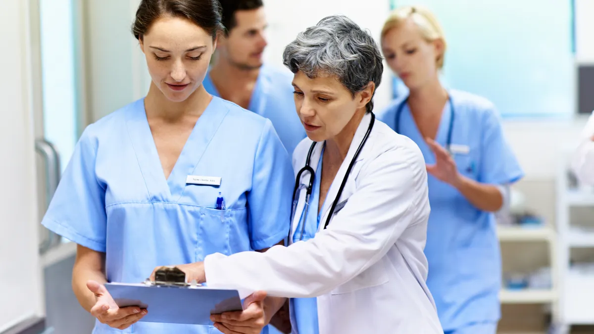 Team of doctors and nurses walking and talking in a hospital corridor