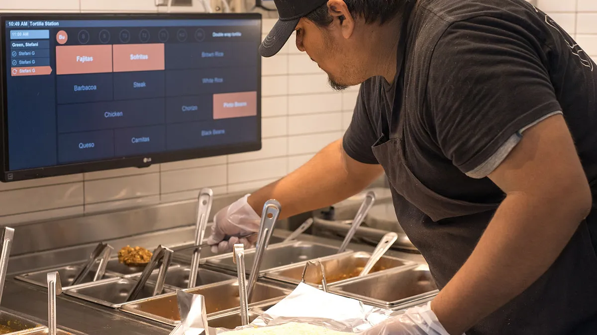 An image of a man preparing a burrito at Chipotle