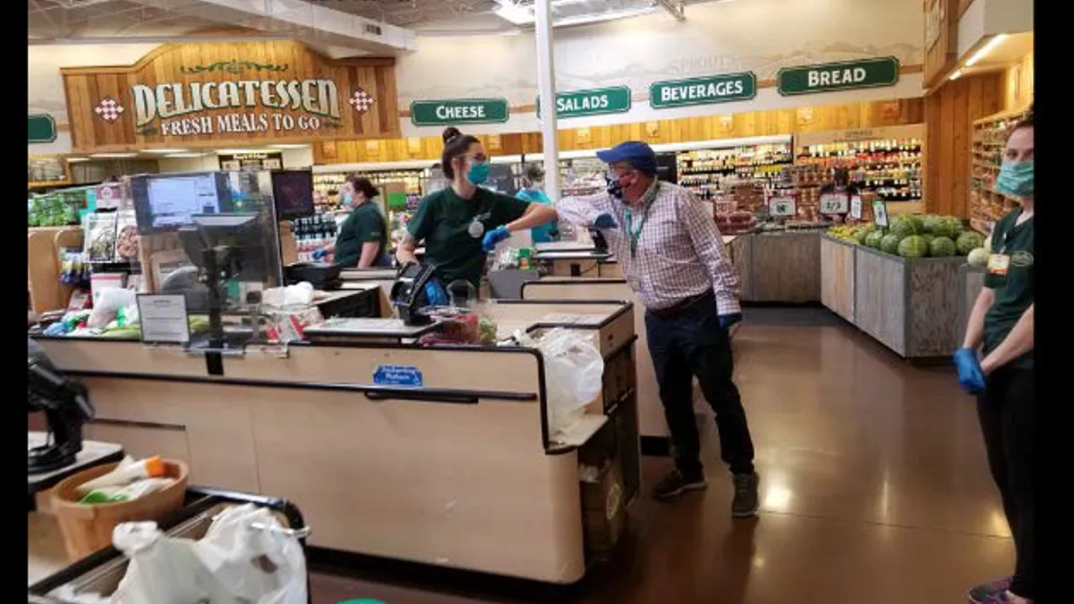 Sprouts CEO Jack Sinclair greeting a cashier in a store