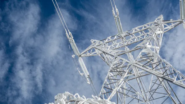 High voltage electric tower on a snowy day in the mountains.