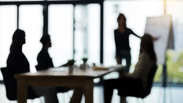 Defocussed shot of a team of businesspeople attending a meeting in a boardroom.