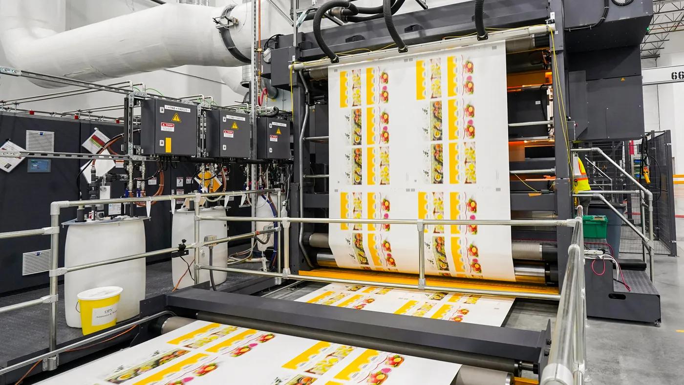 Rolls of paper being printed on industrial machinery.