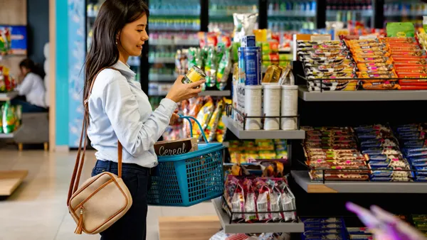 Woman shopping at a convenience store and reading a nutrition label