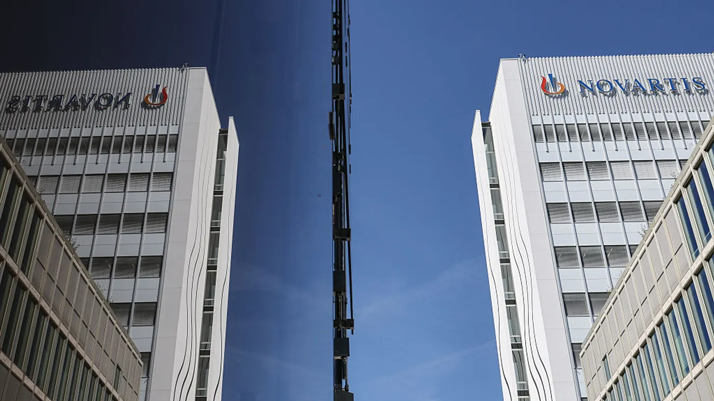 A sign spelling Novartis hangs on the side of a building.