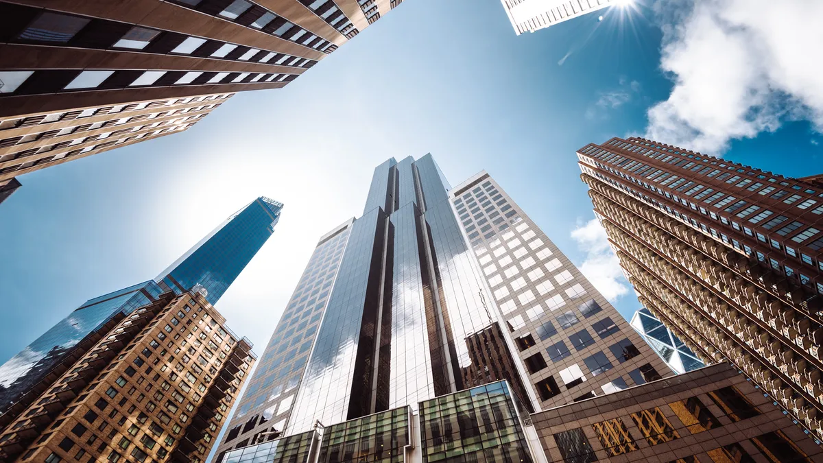 Upward-facing shot of tall buildings and blue sky