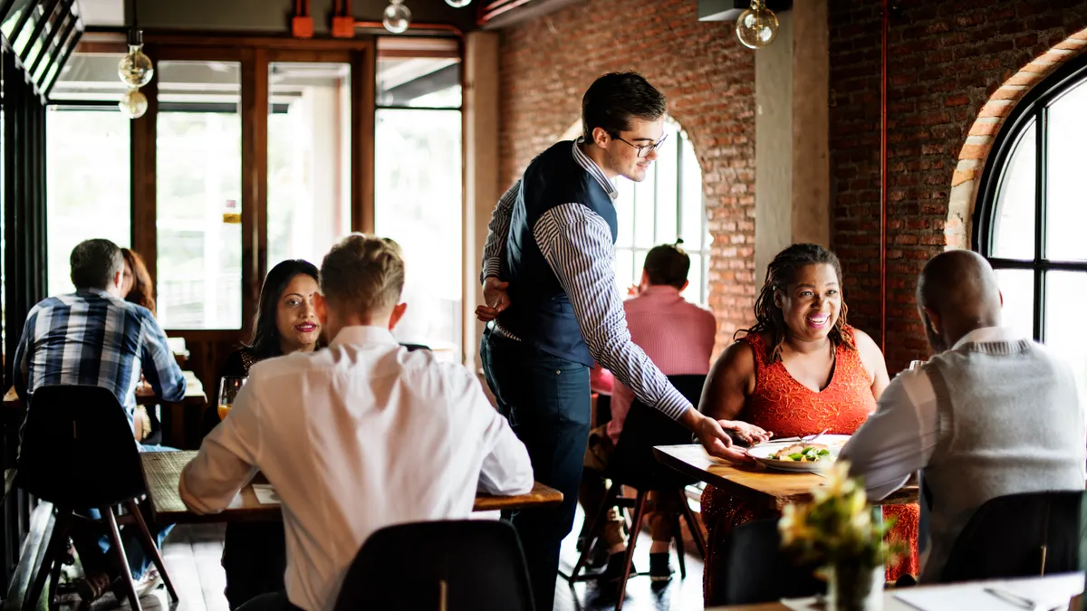 A waiter serves a table at a nice restaurant