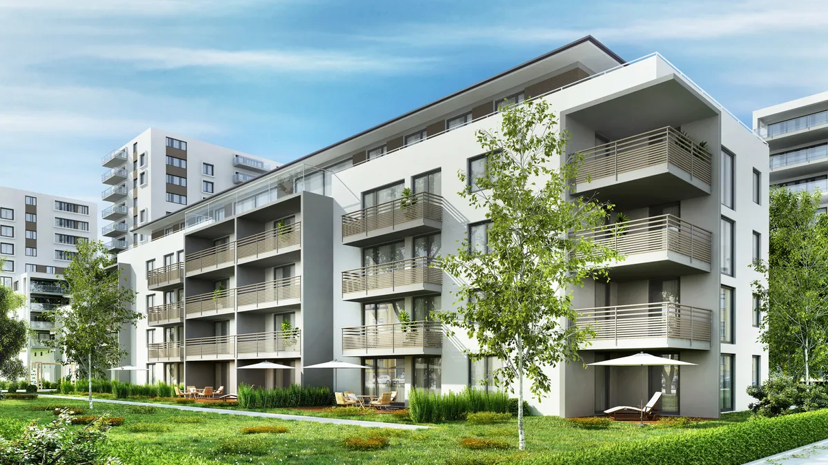 Modern residential buildings with trees and grass in the foreground.