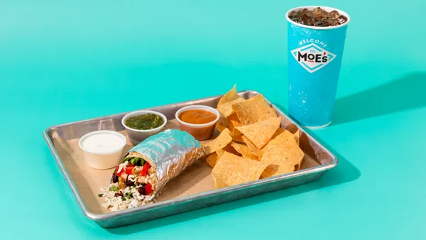 A burritio, chips, drink, side of queso and some salsas.