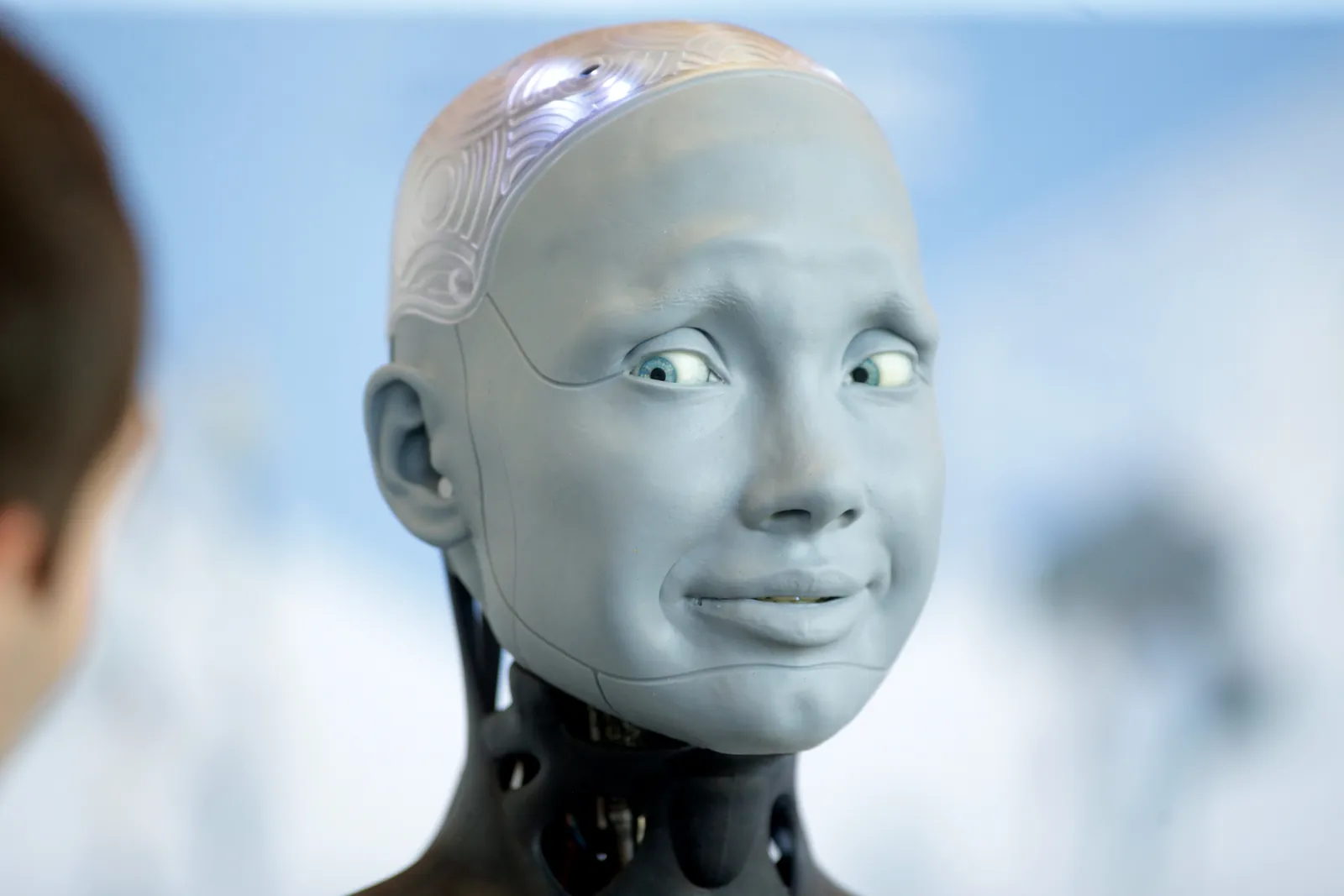 Human-like robot Ameca looks at conference visitor