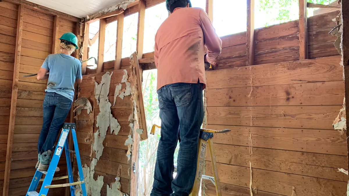 Contractors removing interior shiplap from a circa 1920 homestead on the site of deconstruction contractor training in San Antonio.