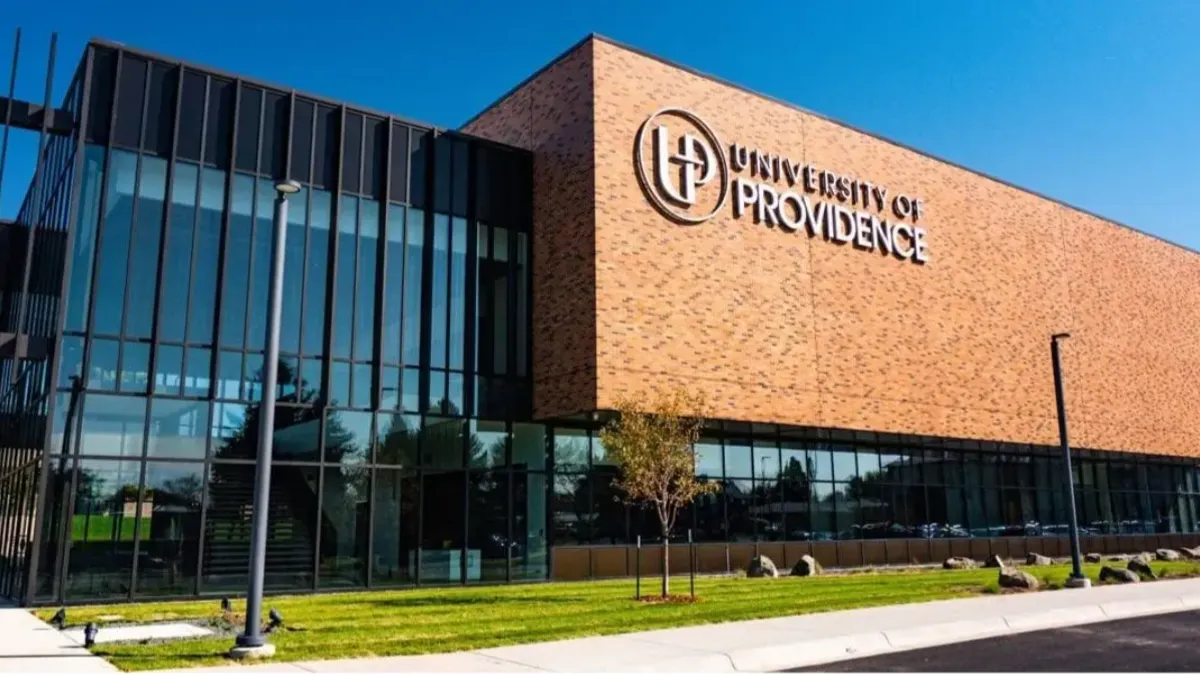 A brick rectangular building with glass lobby on a clear day.