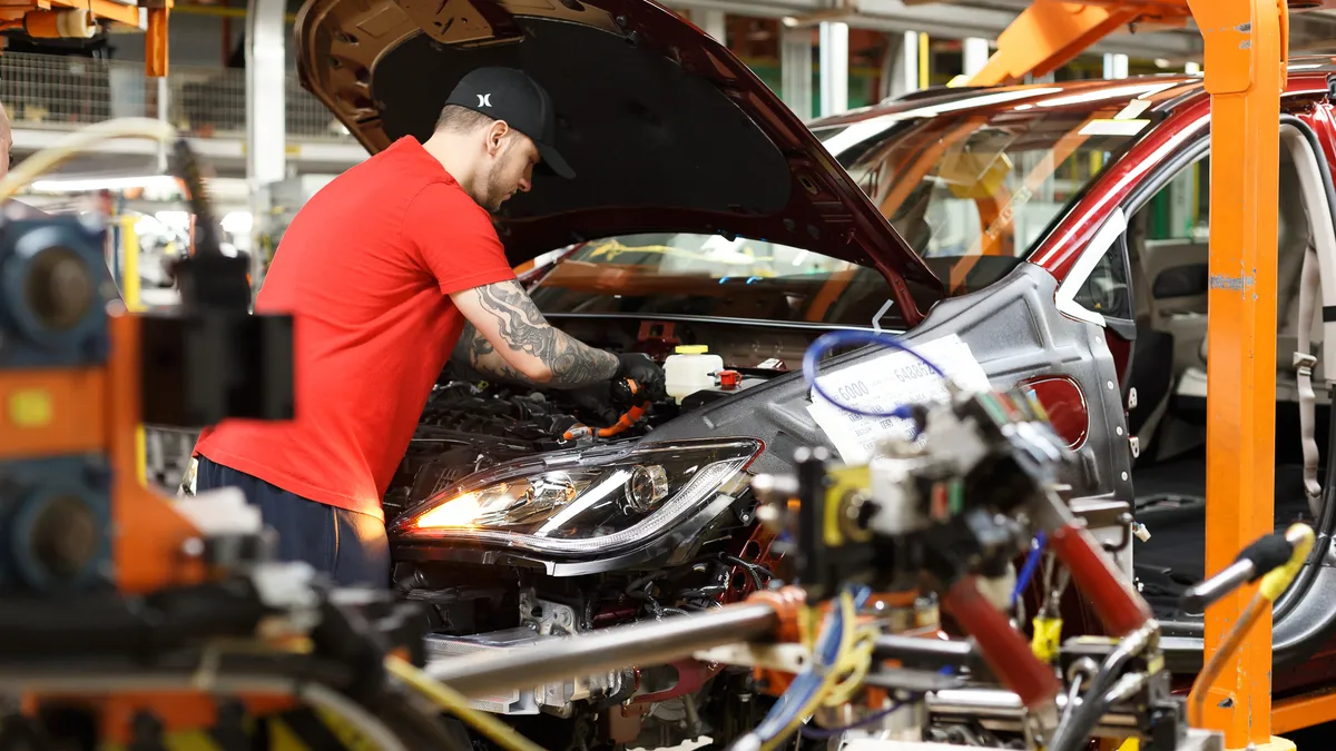 A Stellantis employee assembles a Chrysler Pacifica Hybrid.