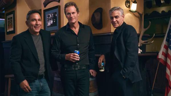 The Casamigos cofounders stand in a room holding cans of Crazy Mountain.