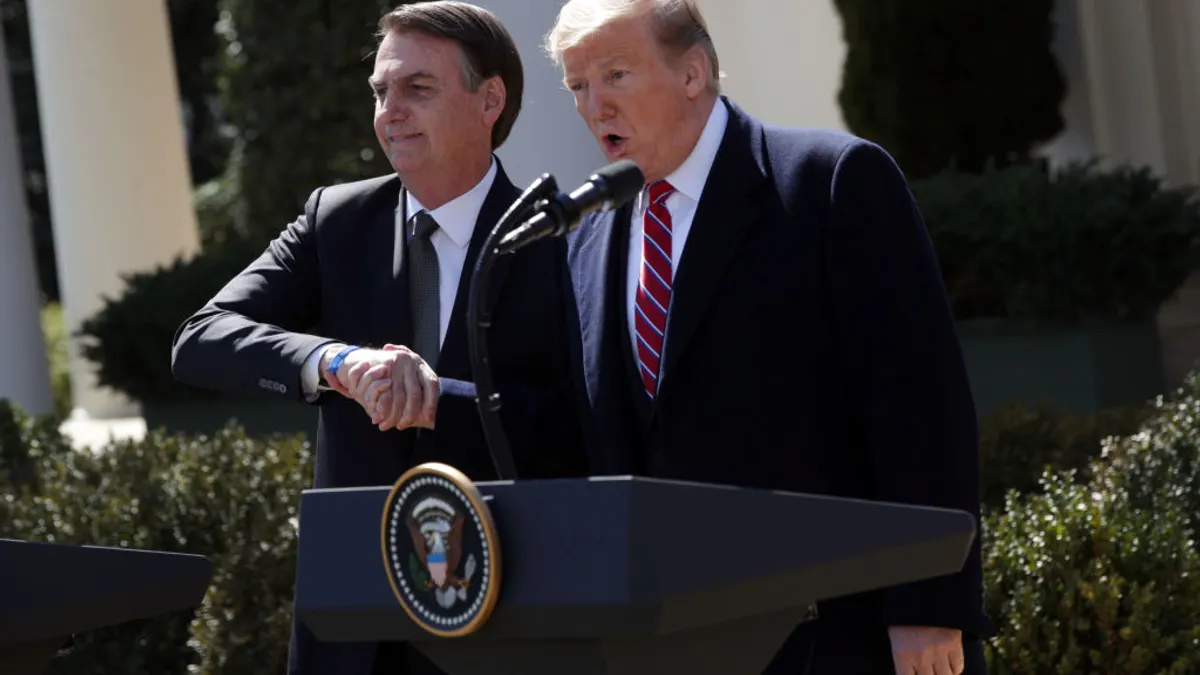 President Donald Trump and Brazilian President Jair Bolsonaro shaking hands at a joint news conference.