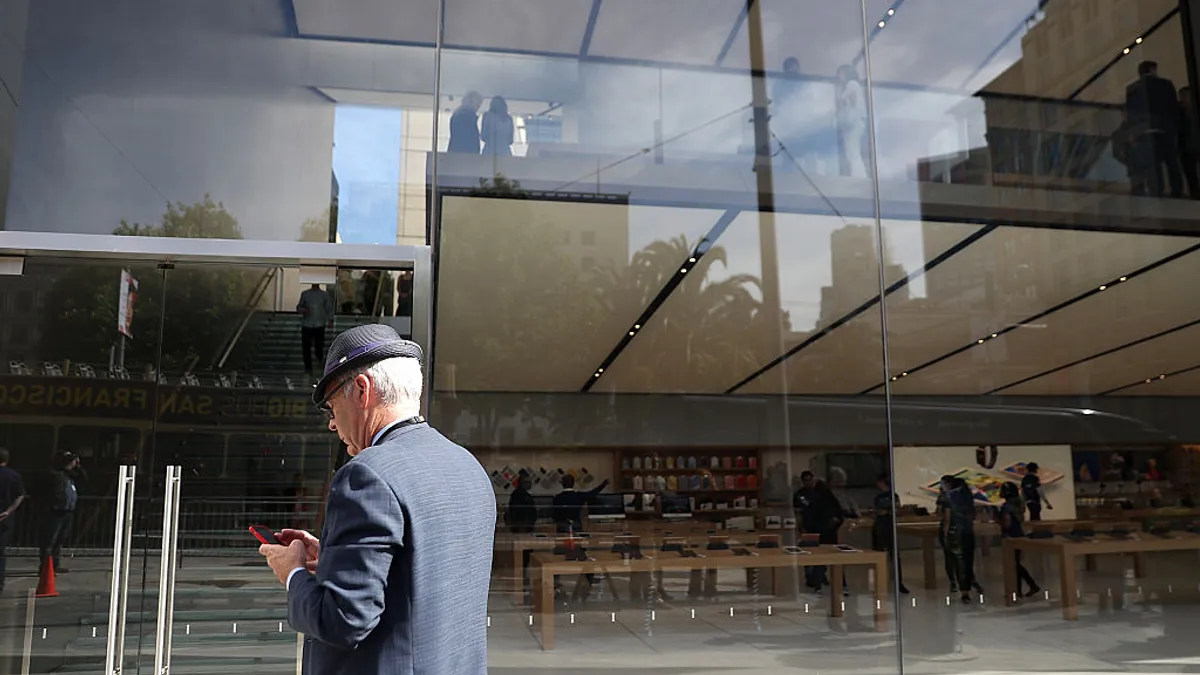 Person waits to enter Apple Store in San Francisco.