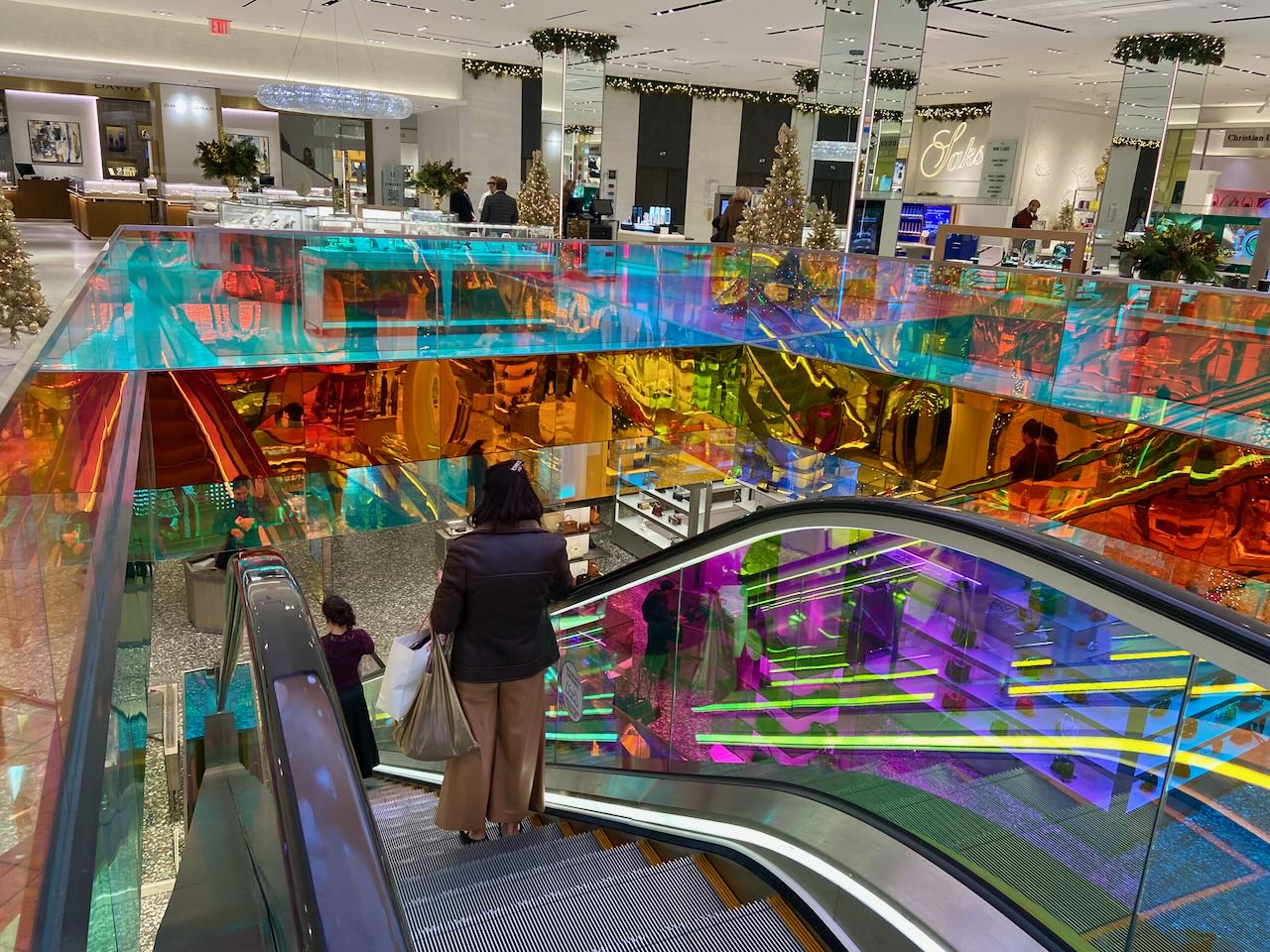 A person on an escalator inside a colorful building interior