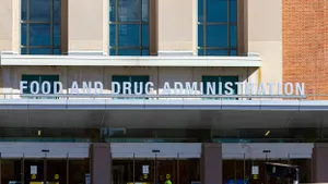 A modern architectural design building featuring a red-brick façade with large glass windows displays a prominent sign of the Food and Drug Administration. 