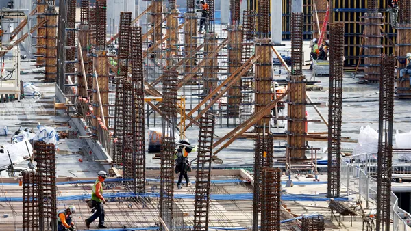 Construction workers build a mixed-use apartment complex