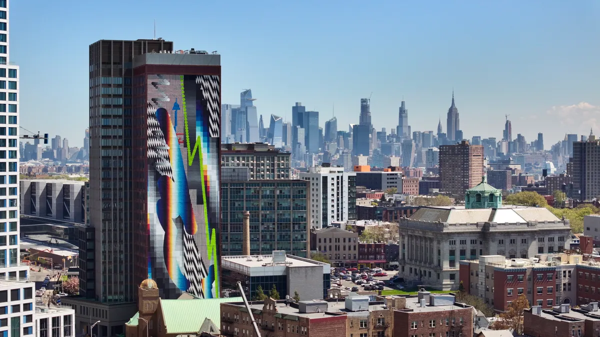 A high-rise apartment building with colorful artwork on the side.