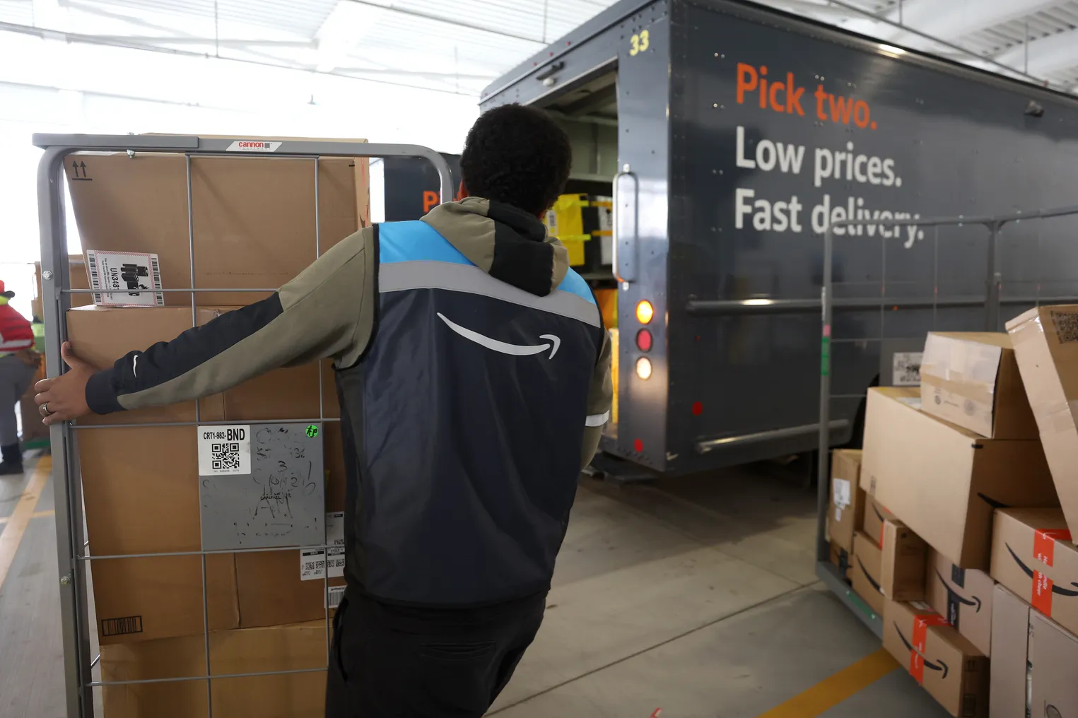 An Amazon driver loads packages into a delivery van at an Amazon delivery station on November 28, 2022 in Alpharetta, Georgia.