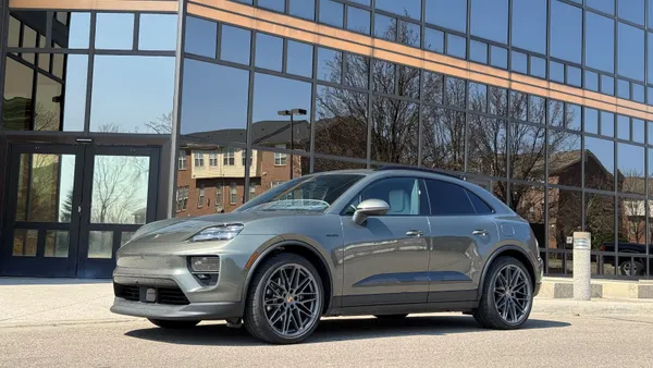 The 2026 Porsche Macan 4S Electric sits in a parking lot with a building in the background.