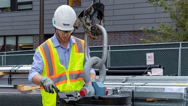 A person wearing safety gear with the branding of Turner Construction on the jobsite.