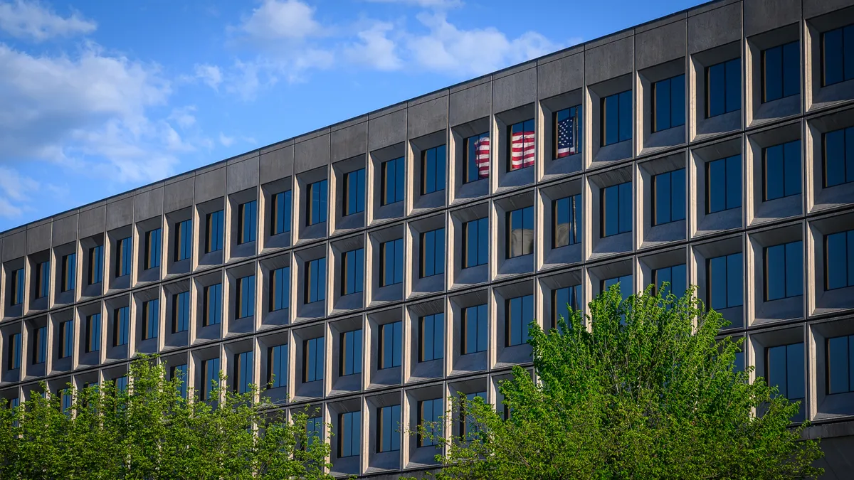 U.S. flag reflects on the glass facade of the DOE.