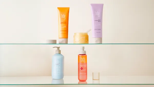A range of colorful personal care product containers on a beige background.