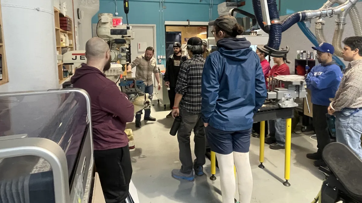 Individuals observe CNC training.