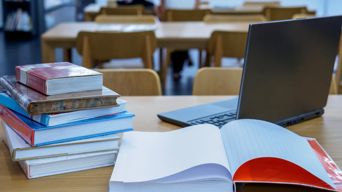 a desk in a classroom has a laptop and papers on it.