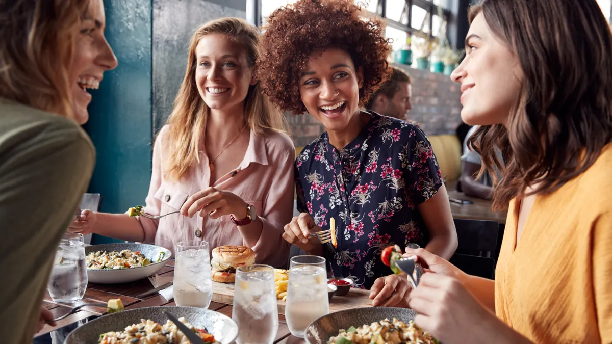 Four Young Female Friends Meeting For Drinks And Food