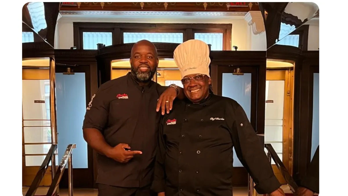 Two chefs standing in front of their restaurant.