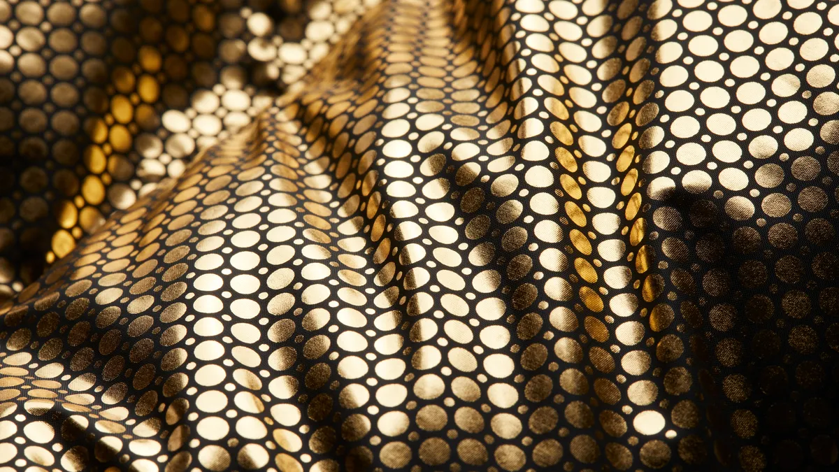 A close-up of a black and gold hexagonal patterned fabric.