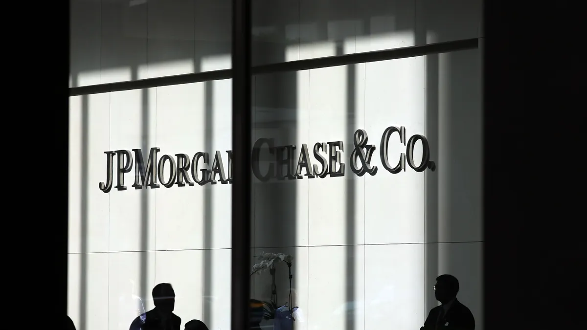 People walk in front of a JPMorgan Chase & Co. sign at its headquarters in New York City.