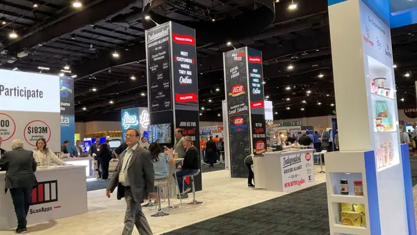 A booth in a trade show exhibit hall with the words "Independent Grocers Alliance" in white letters across the top.