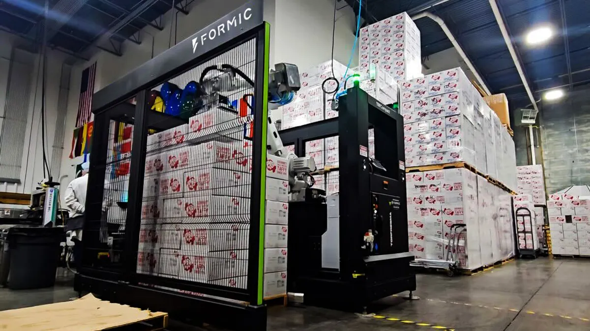 Automated robotic packaging system stacking boxes in a warehouse.