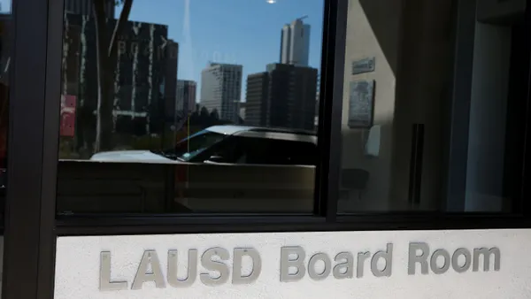 A sign outside a building reads "LAUSD Board Room."
