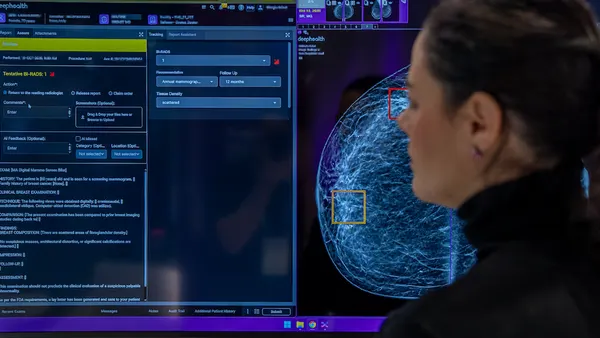 A person looks at a screen that shows an image of tissue with squares in yellow and red.