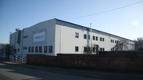 The exterior of an industrial building with Huhtamaki's logo on the side.