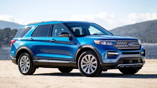 A blue 2021 Ford Explorer SUV parked outdoors with a lake in the background.