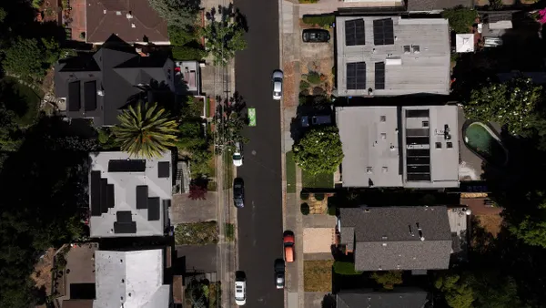 An aerial view of houses topped with solar panels
