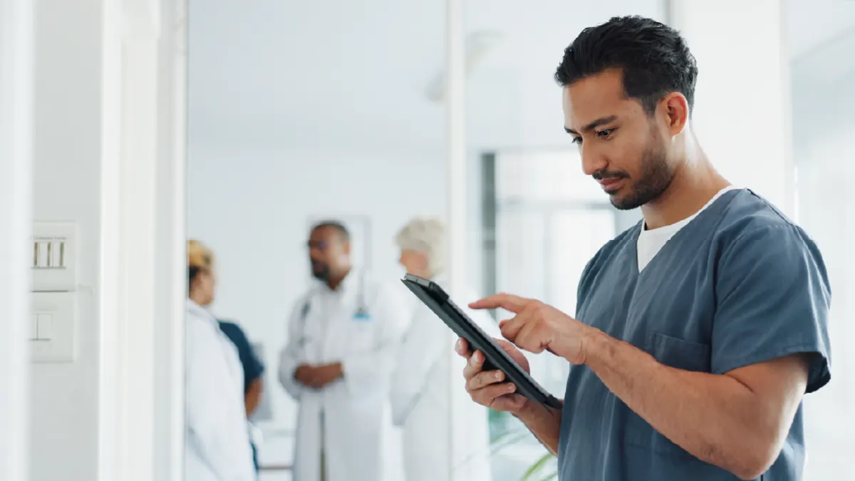A male nurse using a digital tablet