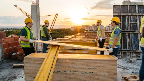 Construction workers lift materials on a jobsite.