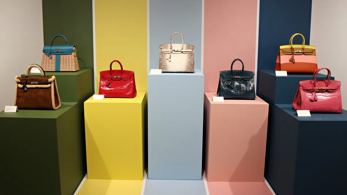 Hermès Birkin bags are on colorful stands displayed at Christie's.