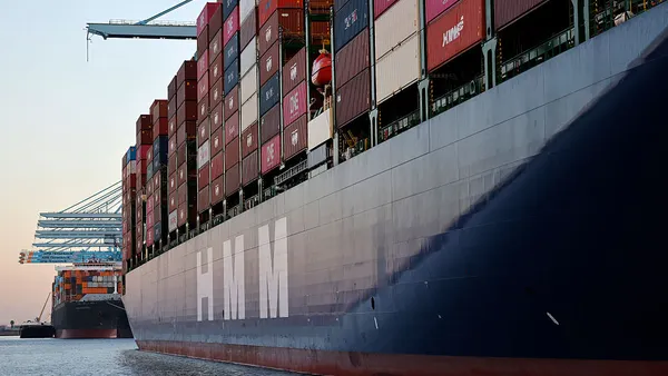 Colorful shipping containers stacked onboard an ocean vessel at a water port.